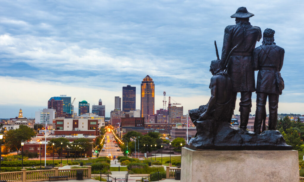 Downtown Des Moines, Iowa with the Pioneers of the Territory statue in the foreground. The statue was made by Karl Gerhardt in 1892.