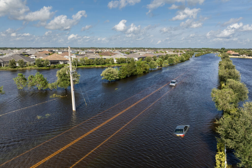 Hurricane Debby flooded city street with trapped car submerged under water in Florida residential area. Consequences of natural disaster. Sarasota, USA - August 6, 2024.